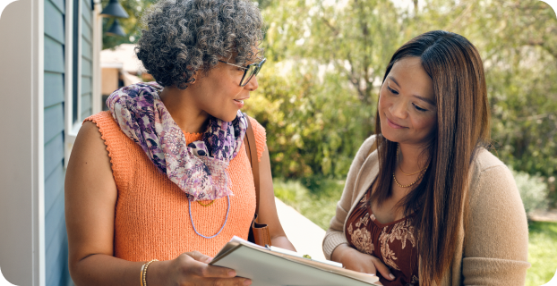 image of one woman holding paperwork with another woman looking at the paperwork