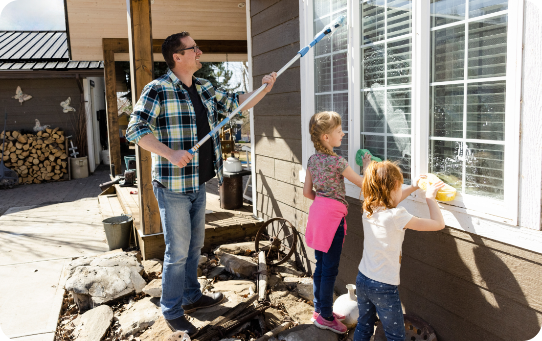father and children washing house windows
