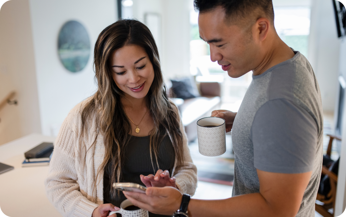 couple checking phone over coffee