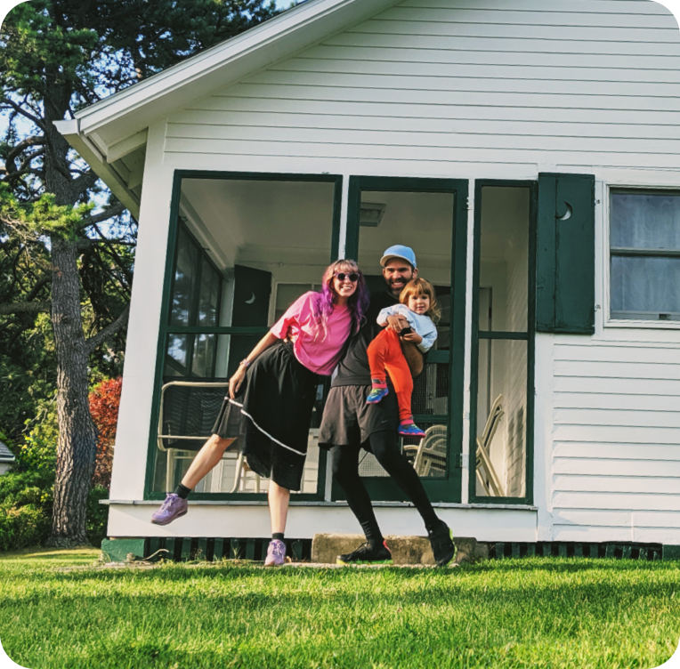 Image of young family standing in front of a house